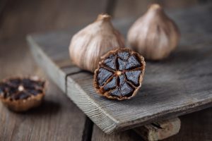 Organic,Fermented,Black,Garlic,On,Wooden,Table
